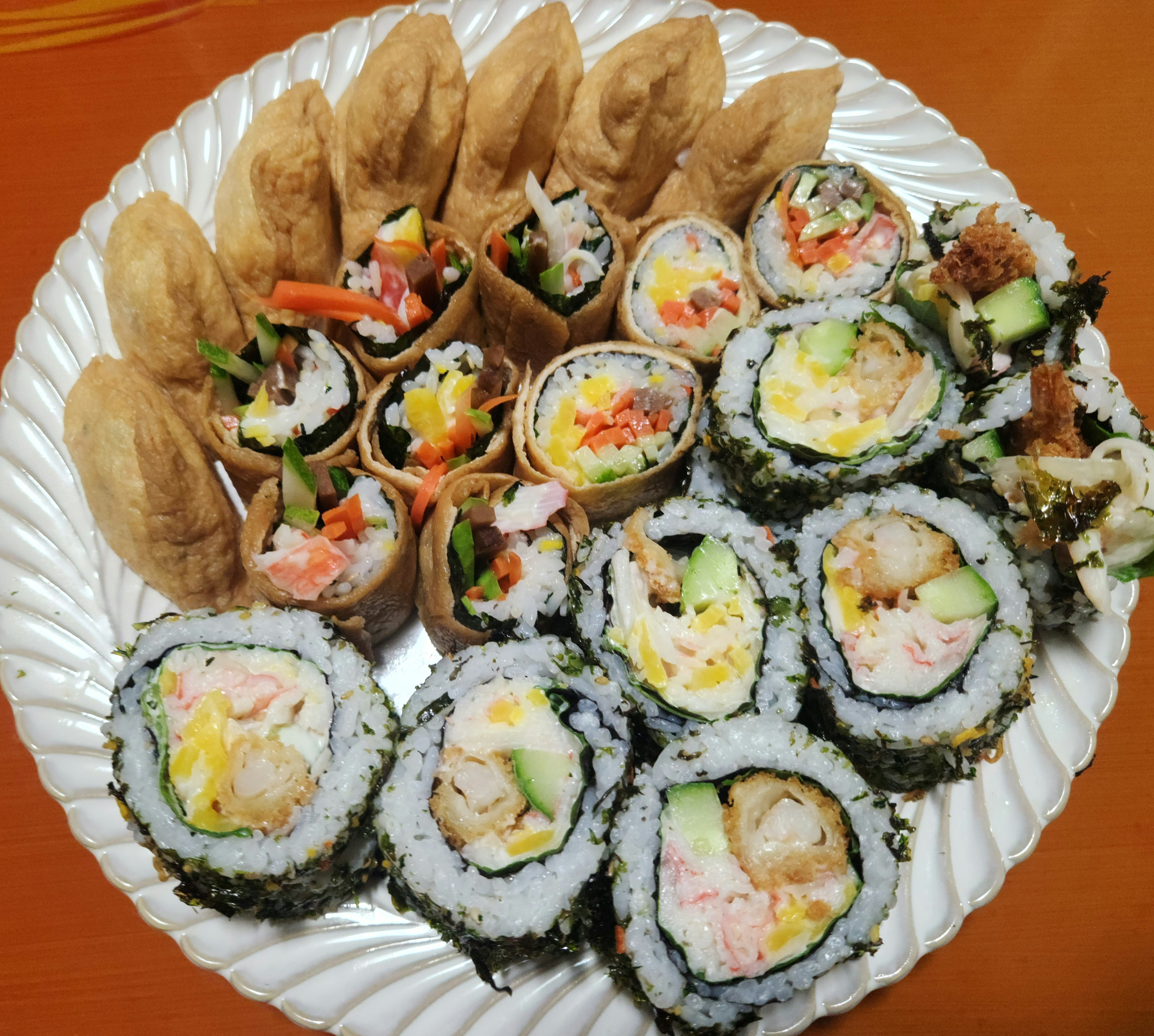 유부초밥과 다양한 종류의 김밥이 담긴 접시