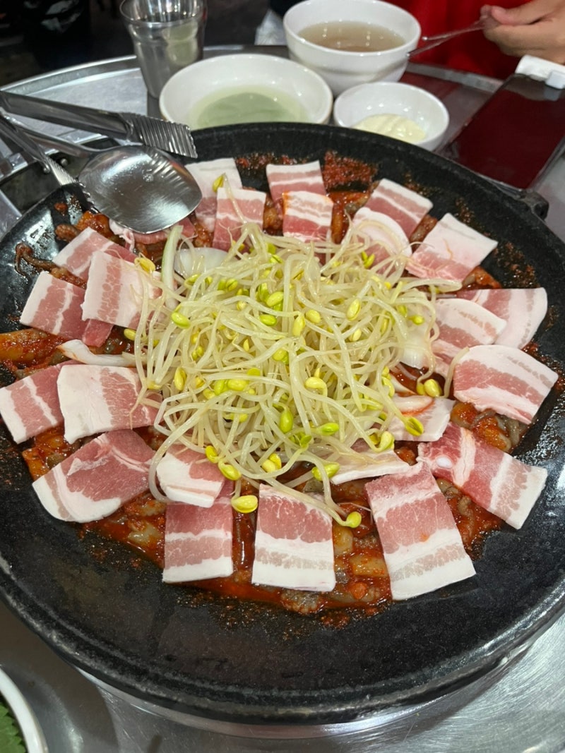 삼겹살과 콩나물이 둘러진 불판